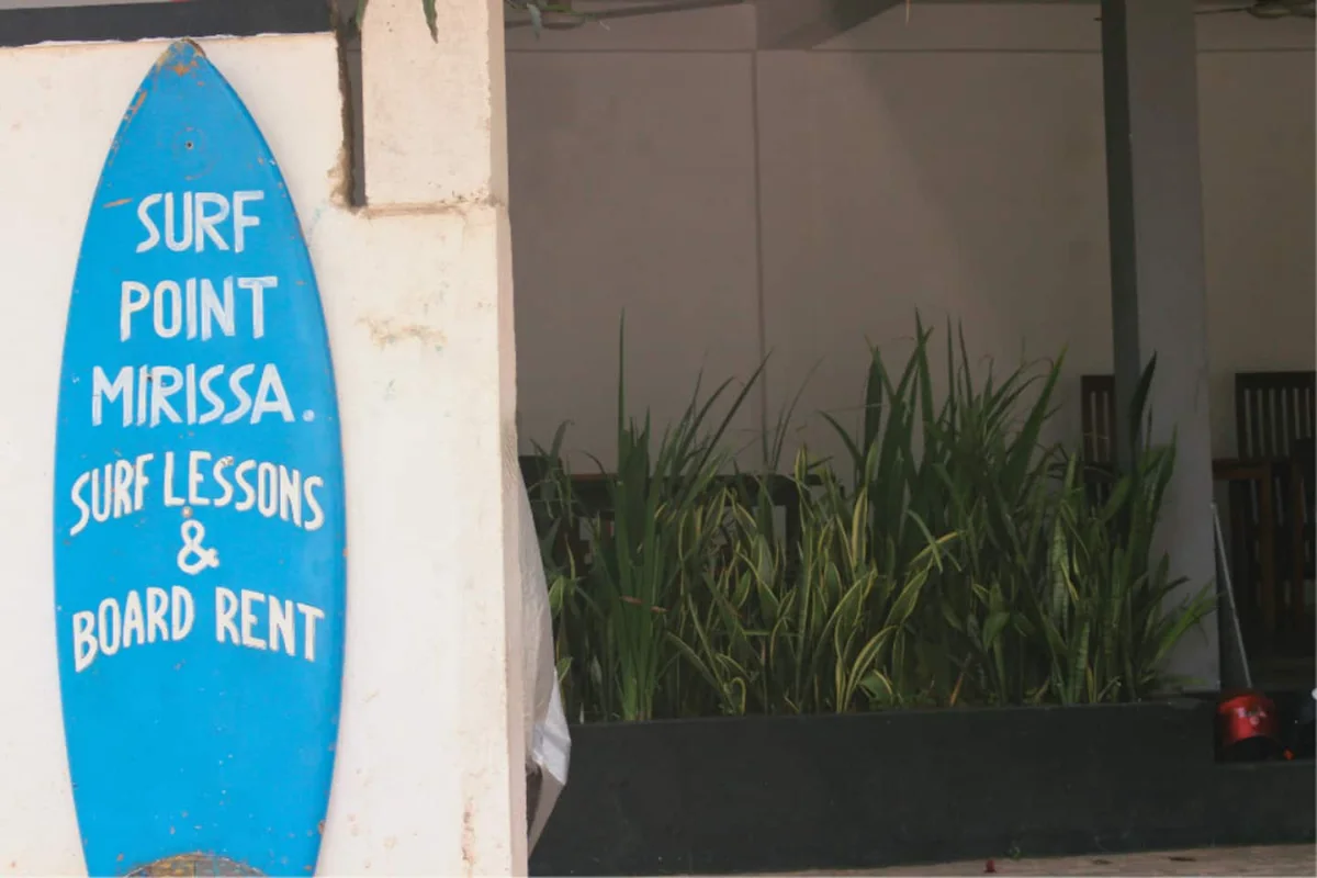 El cartel de clases de surf, en la esquina